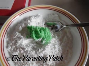 Rolling the Grinch Cookie Dough in Powdered Sugar and Corn Starch