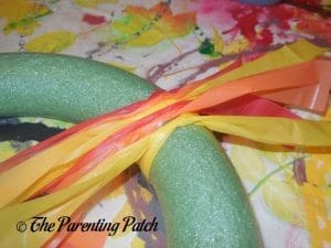 Tying Tablecloth Strips Around the Foam Wreath for the Tablecloth Ribbon Thanksgiving Wreath Craft