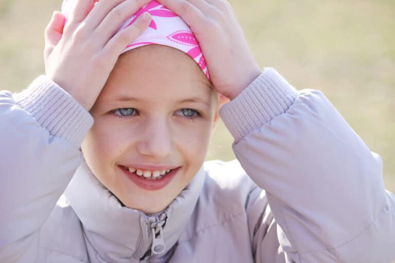 Child wears bandana on head due to hair loss from chemotherapy