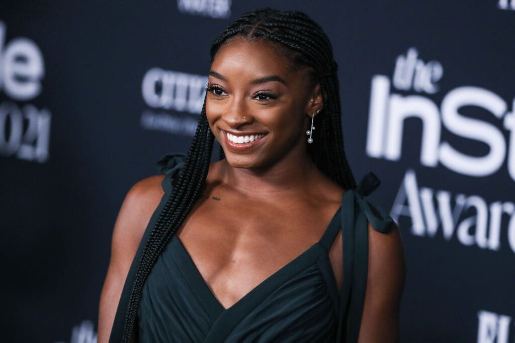 Gymnast Simone Biles wearing an Aliette dress, Christian Louboutin shoes, and Matteo jewelry while carrying a Judith Leiber bag arrives at the 6th Annual InStyle Awards 2021 held at the Getty Center on November 15, 2021 in Los Angeles, California