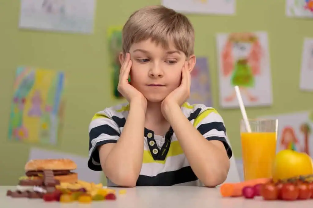boy looks at food items on table