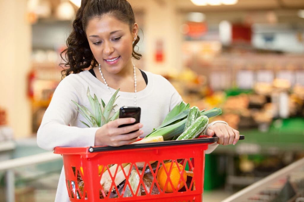 Smiling woman using mobile phone in shopping store