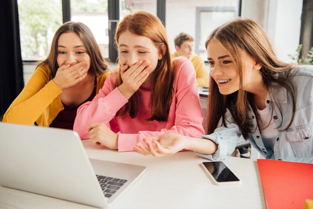 Girls looking at laptop are surprised