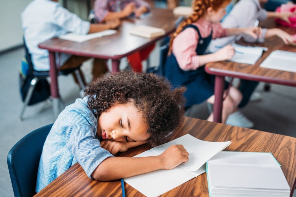 child sleeping on desk