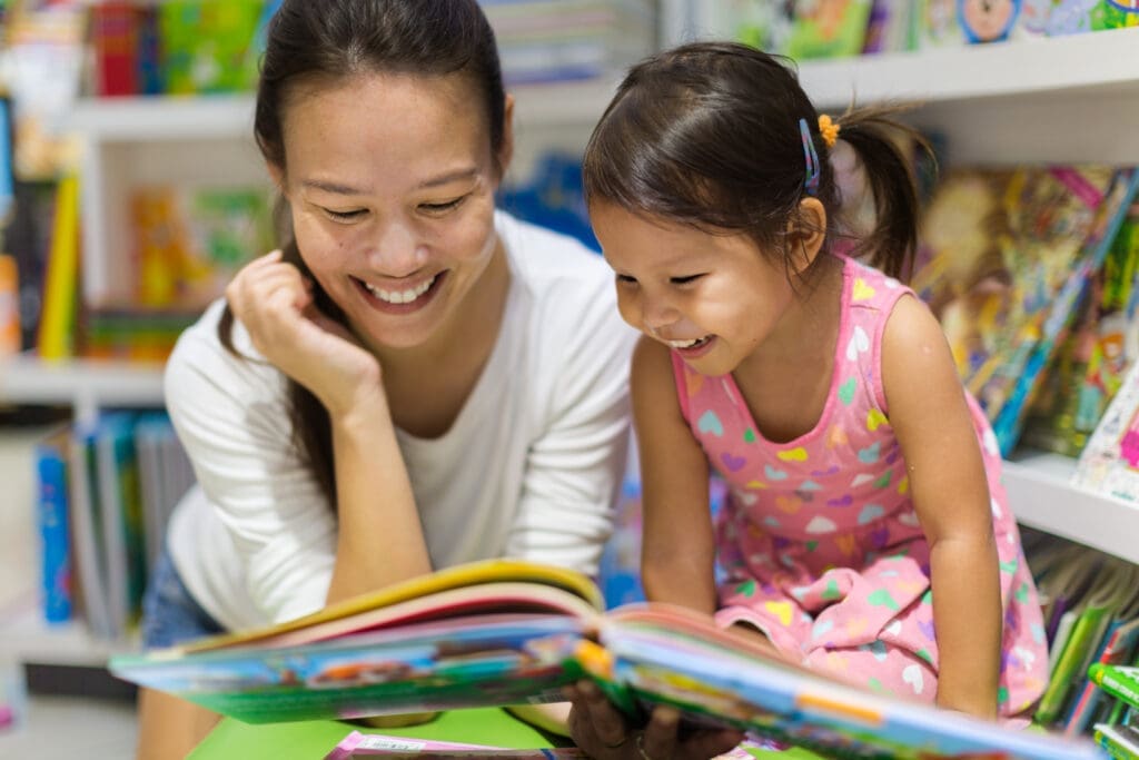 Mother and daughter enjoying a book together at the bookstore. Education.