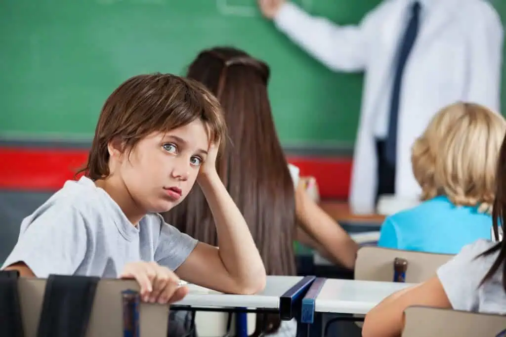 Portrait Of Little Boy Leaning At Desk