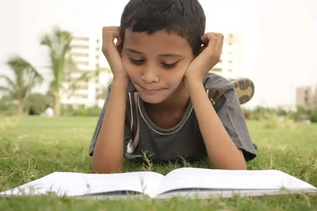 kid studying in grass