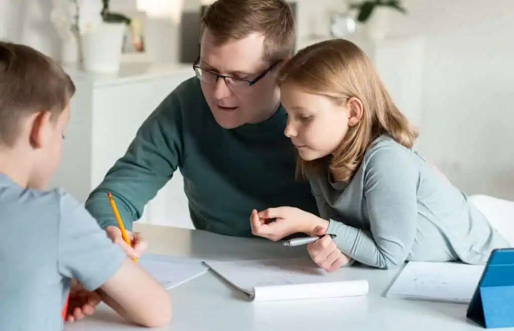 father helps kids with homework