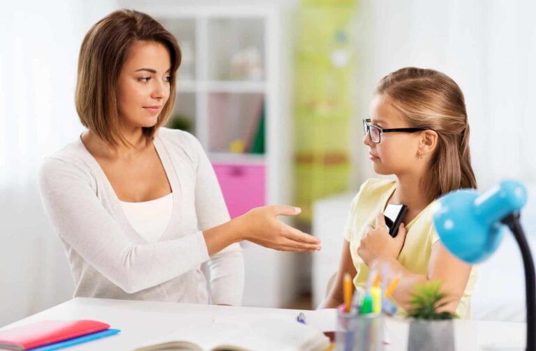 displeased mother taking smartphone from daughter