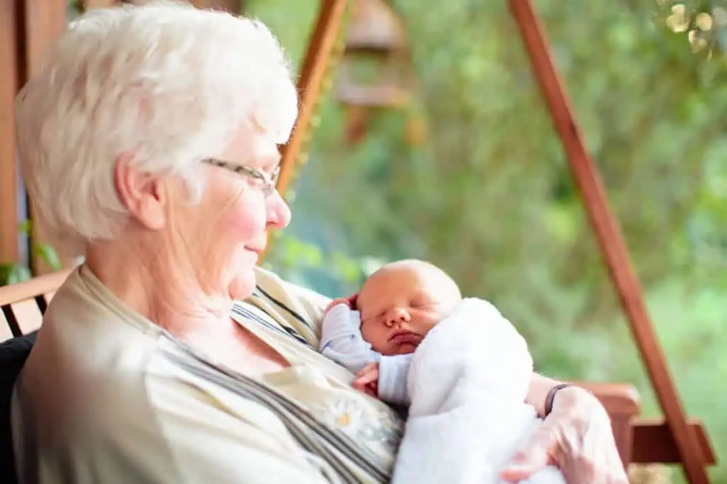 Grandmother meeting newborn grandchild in garden