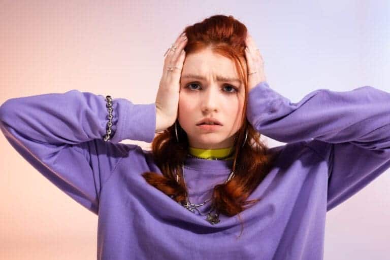 Worried stressed teen girl, on purple and beige background