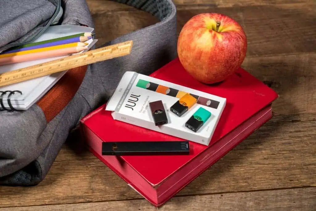 Juul pods and device sit among school supplies