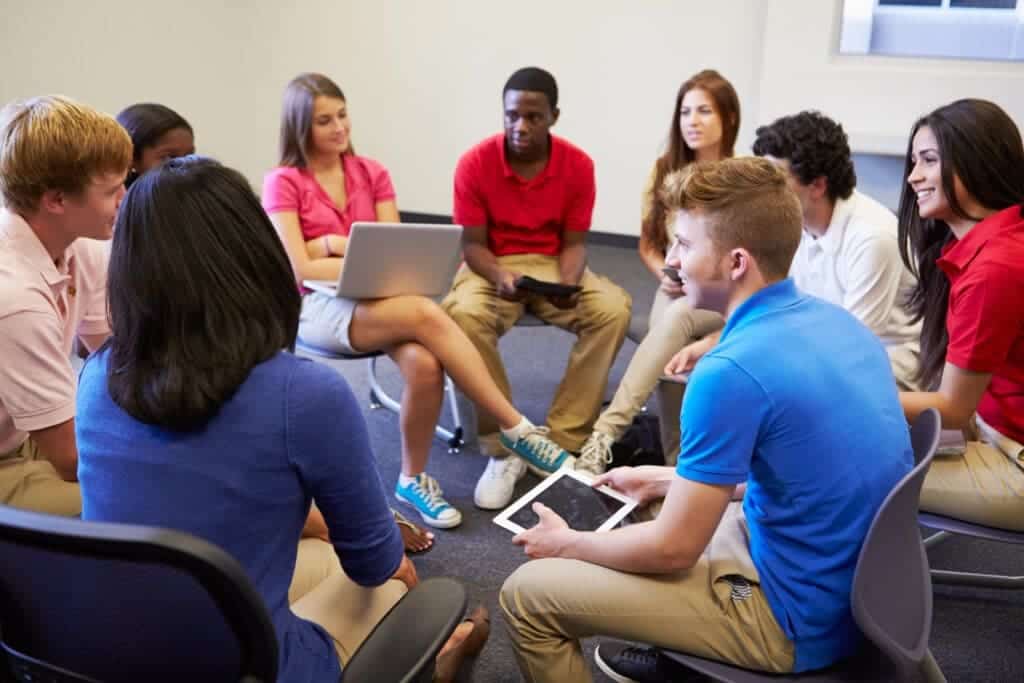 Students have discussion while sitting in circle