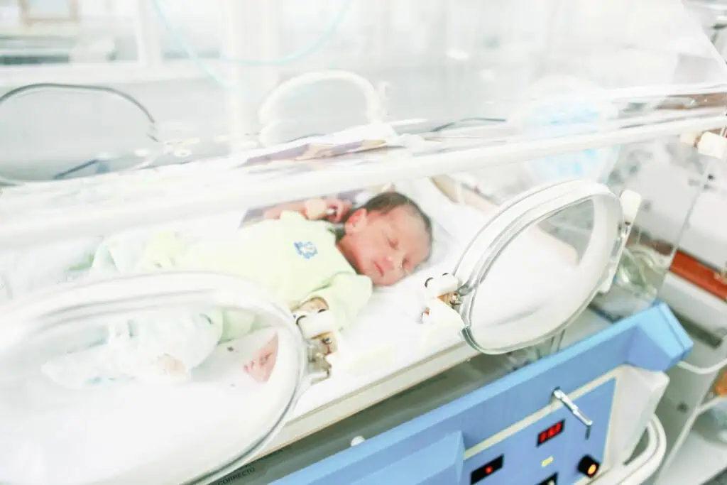 Newborn in NICU incubator