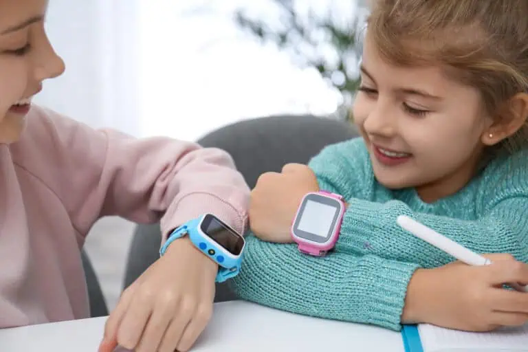 Two young girls compare their smartwatches