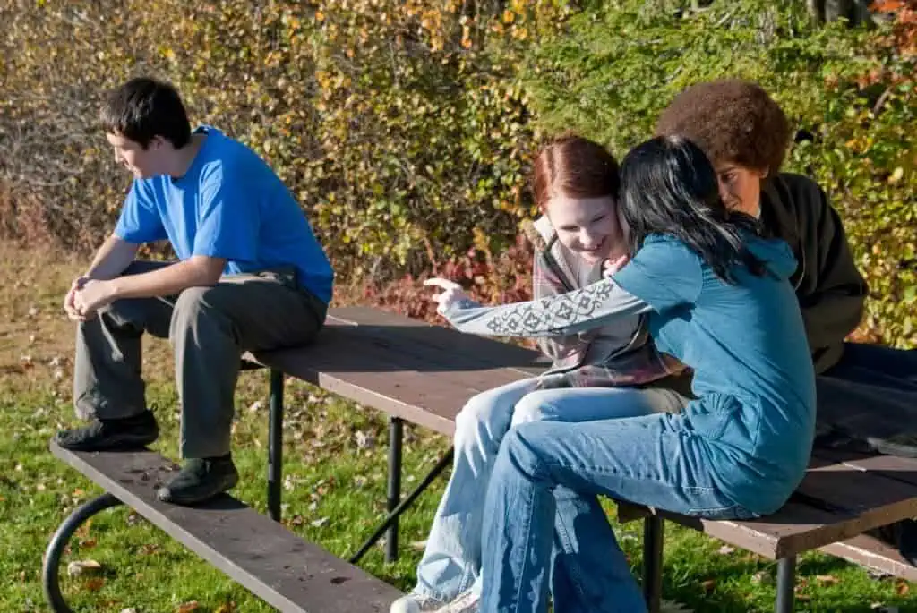 One student is isolated while others tease him