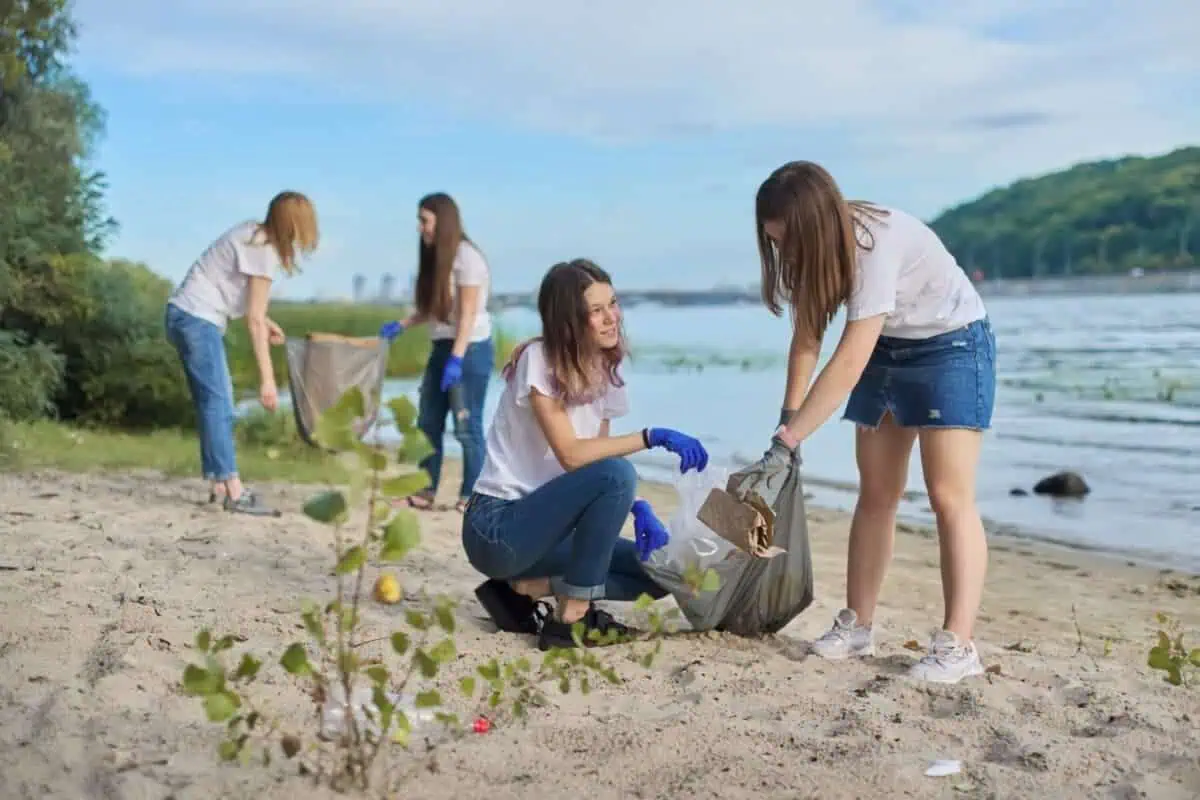 Teens work together to clean up trash on beach