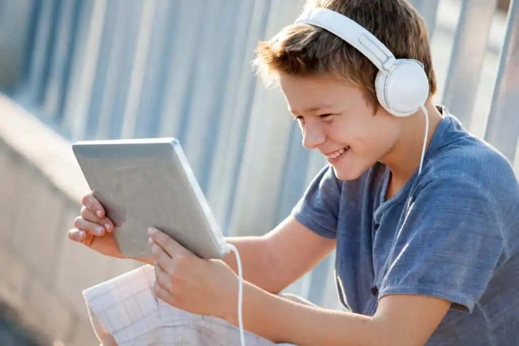 Child uses tablet with headphones