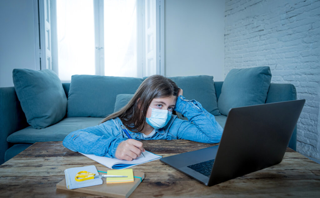 Teenager uses mask and laptop during covid pandemic