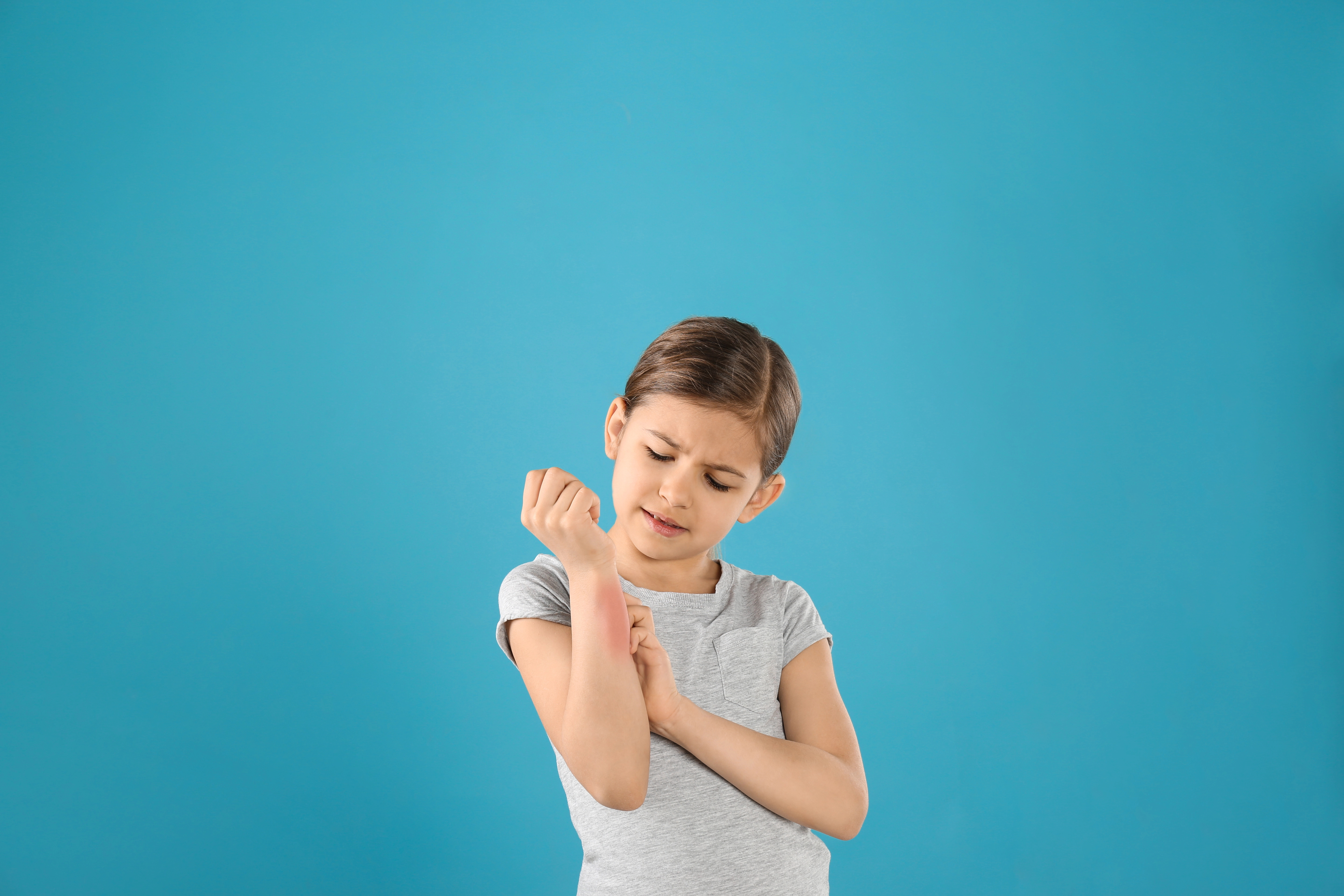 Little girl scratching forearm
