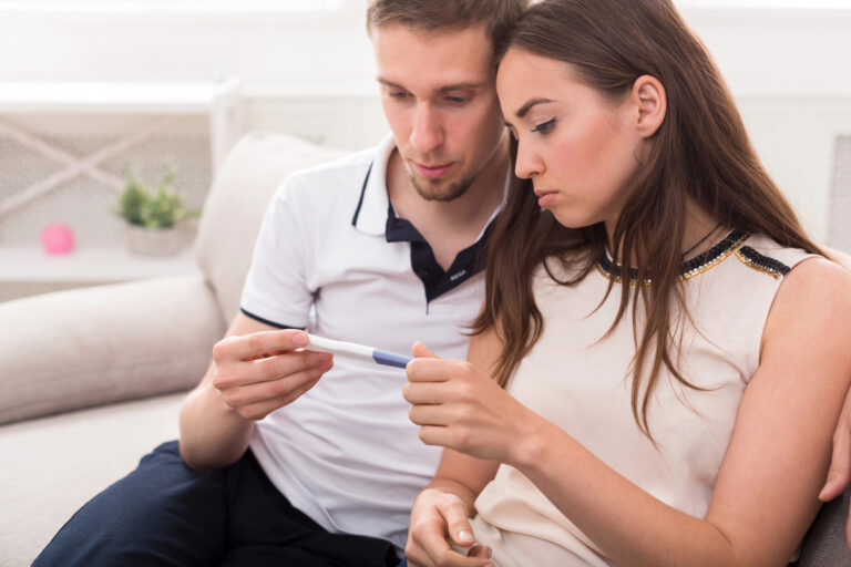 Young couple looks at pregnancy test together