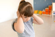 Little girl covers ears