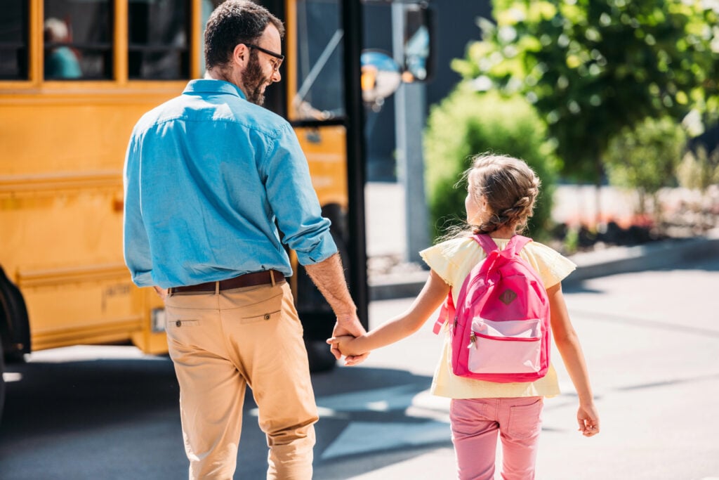Dad is walking daughter to the bus stop
