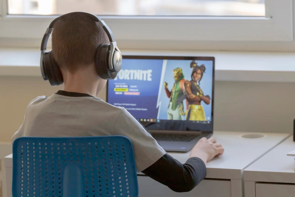 Vilnius, Lithuania - March 2, 2019: Child playing Fortnite game. Fortnite is popular online video game developed by Epic Games