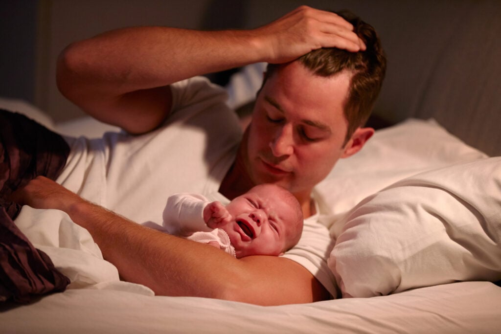 Father Lying With Baby Daughter