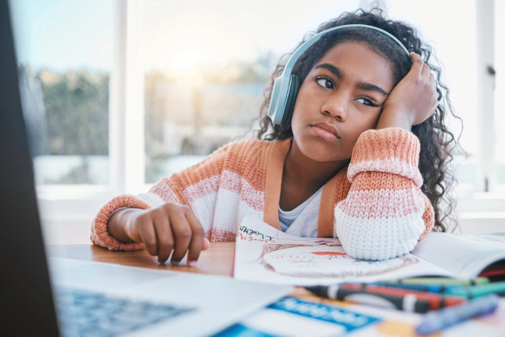 Girl wears headphones will doing work but is still distracted