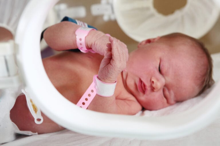 Macro photo of a newborn baby's hands. The salvation of infants in Pediatrics. The face is out of focus. Copy space.