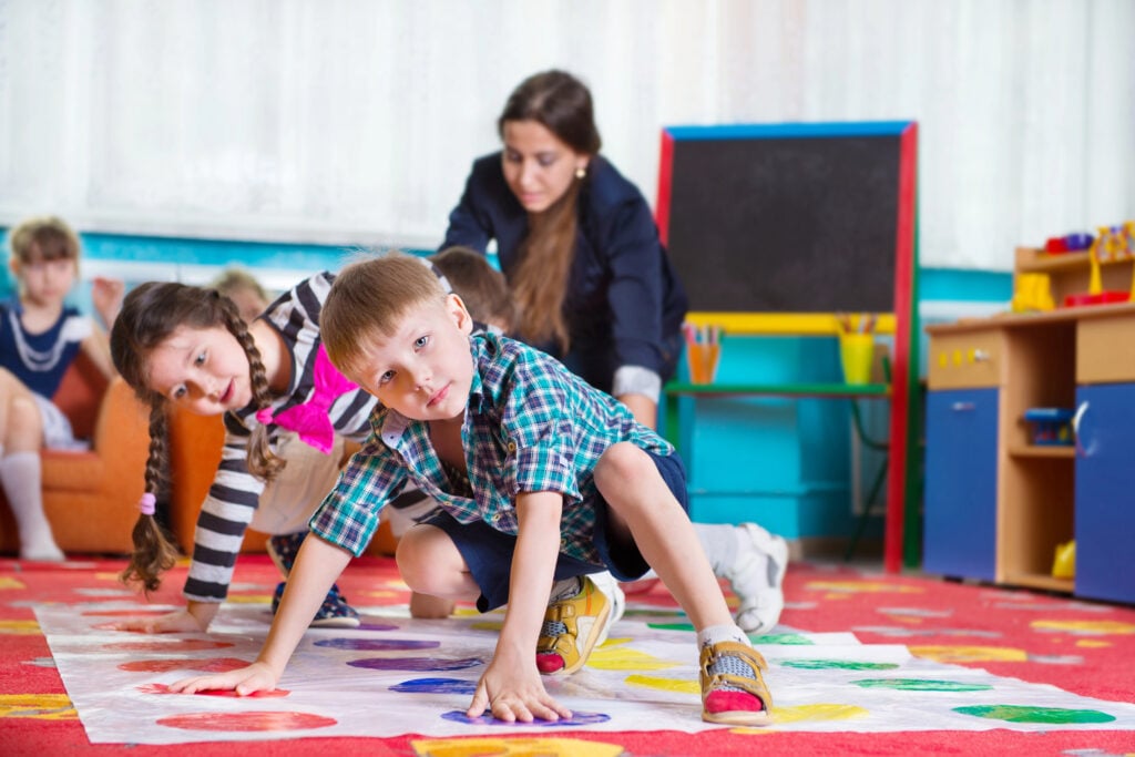 Cute toddlers playing in twister game