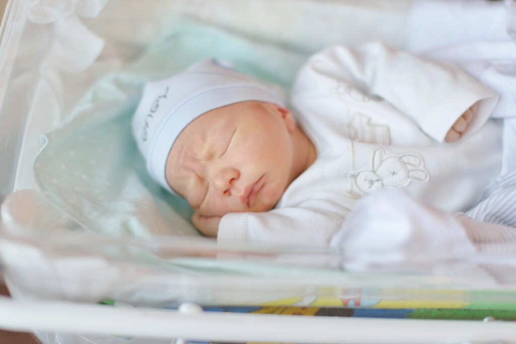 Newborn baby lies in bed