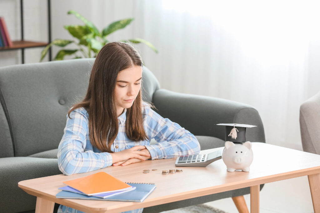 Teenage girl with savings for education and calculator at home