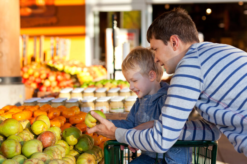 A child and his parent pick out produce