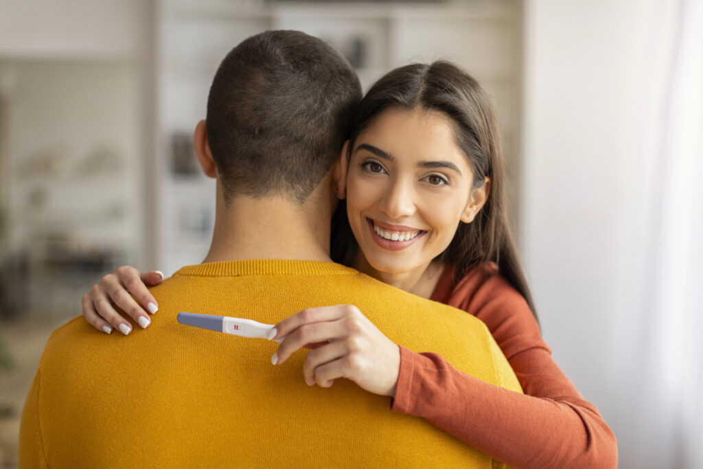 Couple is happy hugging with pregnancy test