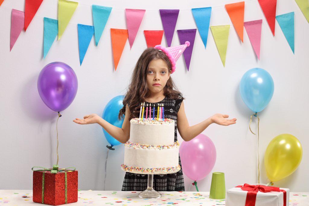 Disappointed girl with a birthday cake