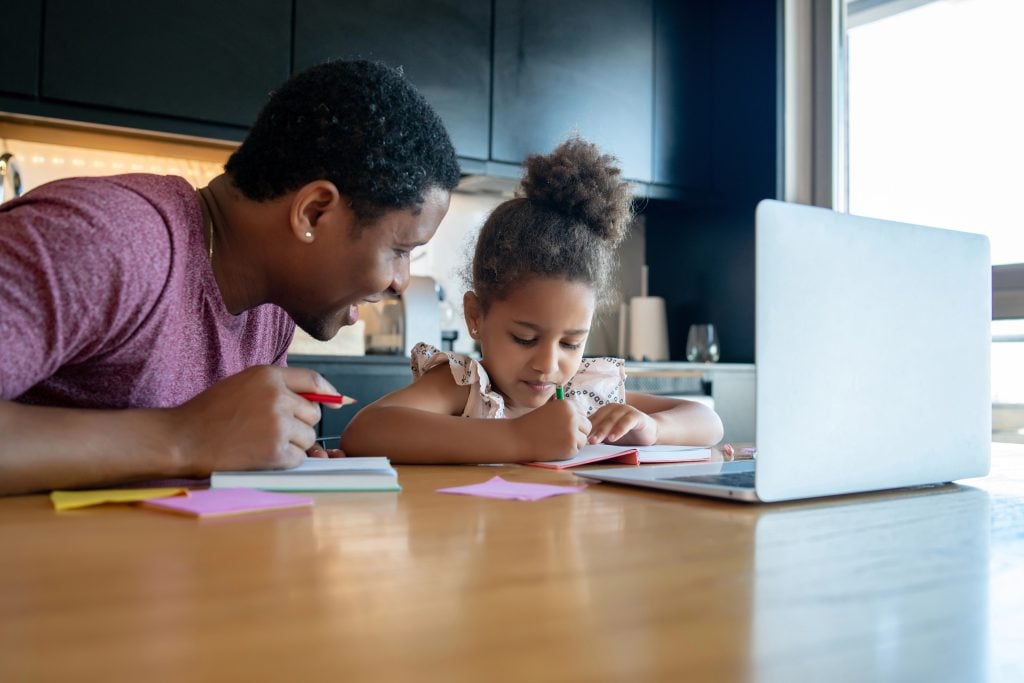 A father helping his daughter with homeschool.