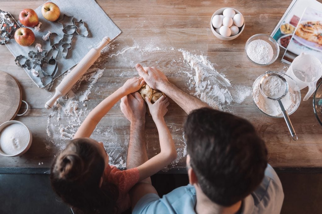 A lawnmower father and daughter cooking together