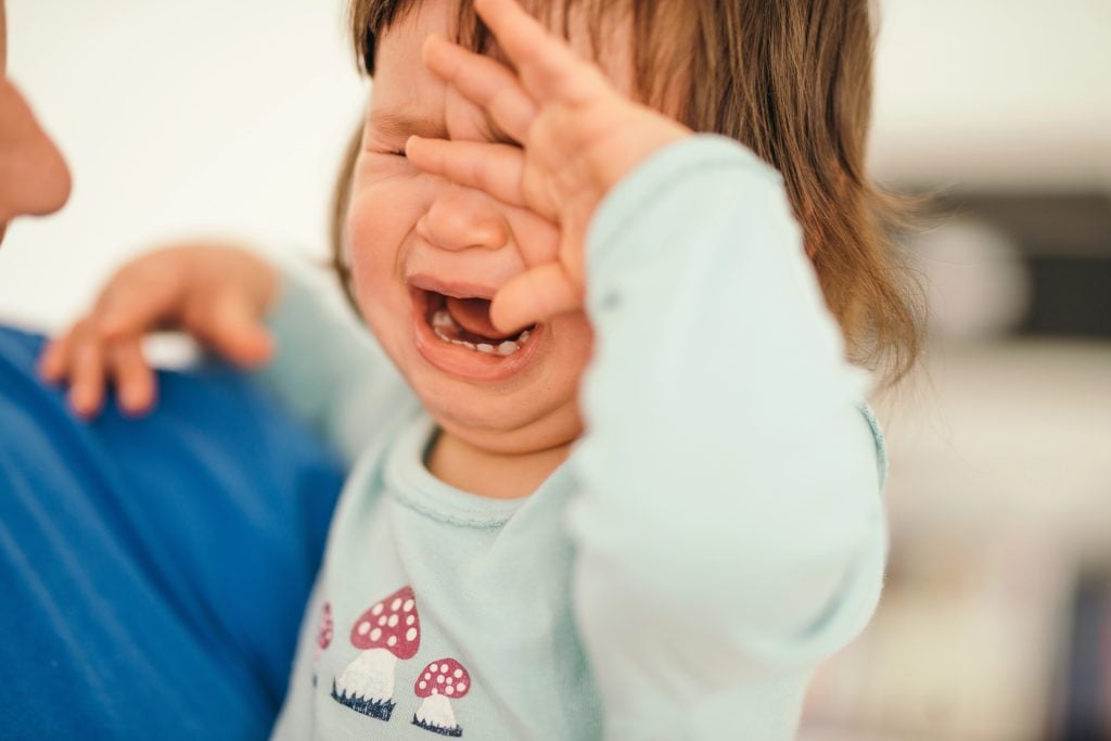 little girl crying on the daddy hands due to uninvolved parenting