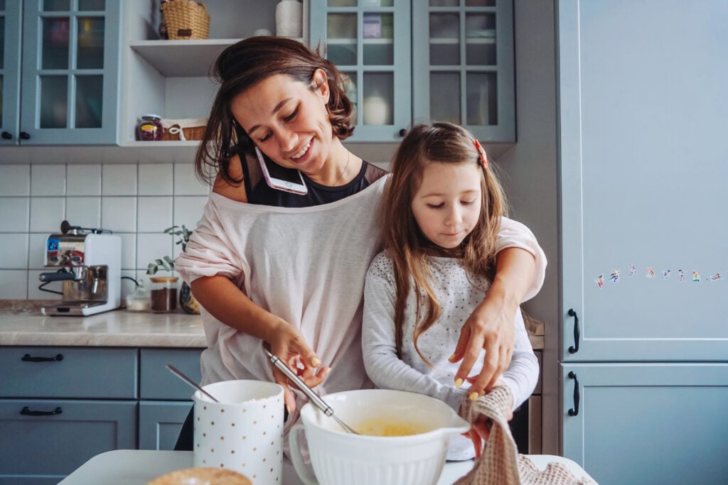 mom teaches her little daughter to cook food