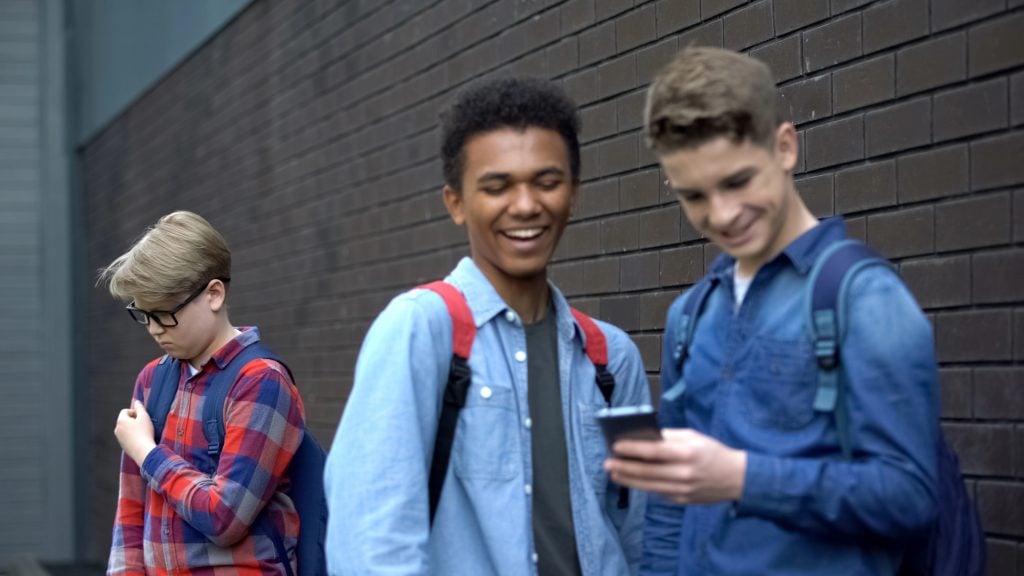 Evil schoolmates laughing at video about bullied boy, offensive post in network