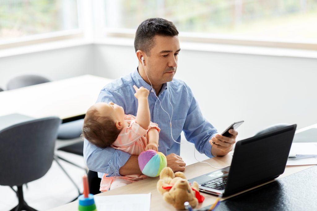 father with baby working at home office