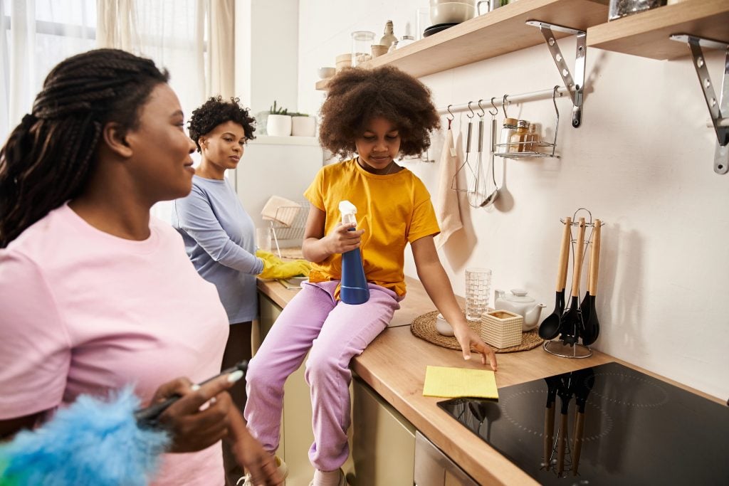 Family bonds strengthen as they share chores and laughter together in the cozy kitchen space.