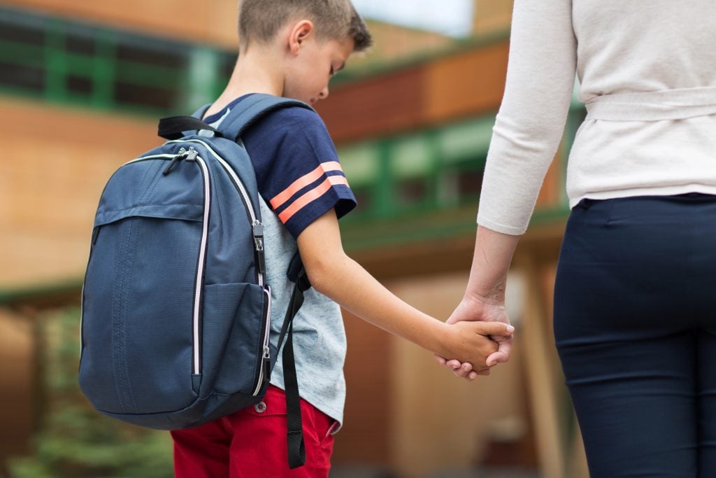 elementary student boy with mother at school yard
