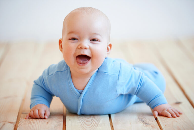 Cute happy baby boy crawling on the floor
