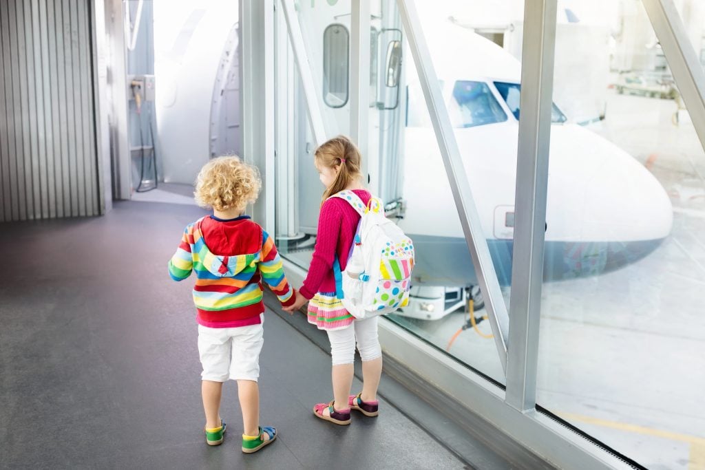 Kids travel and fly. Child at airplane in airport