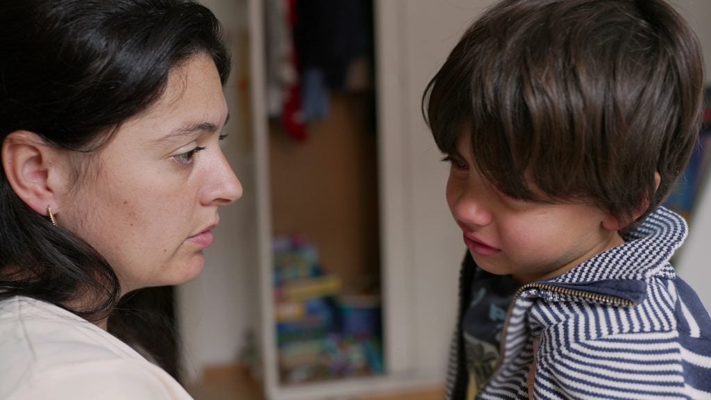 Mother and son having a serious conversation. boy is visibly upset while the mother listens attentively, moment of emotional connection and communication in a home setting