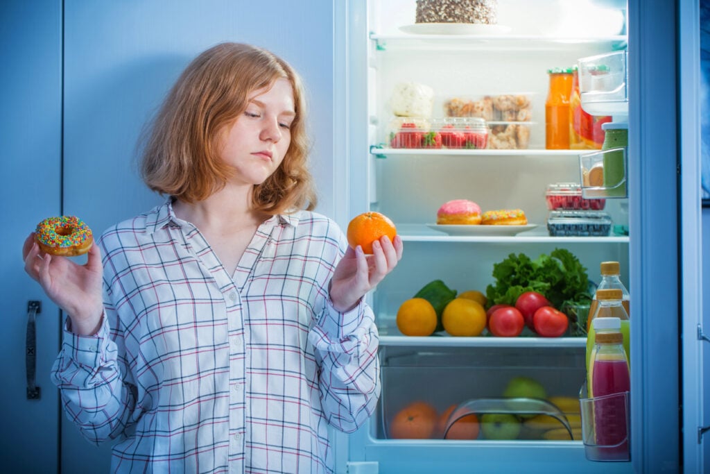 teenager girl at fridge with food