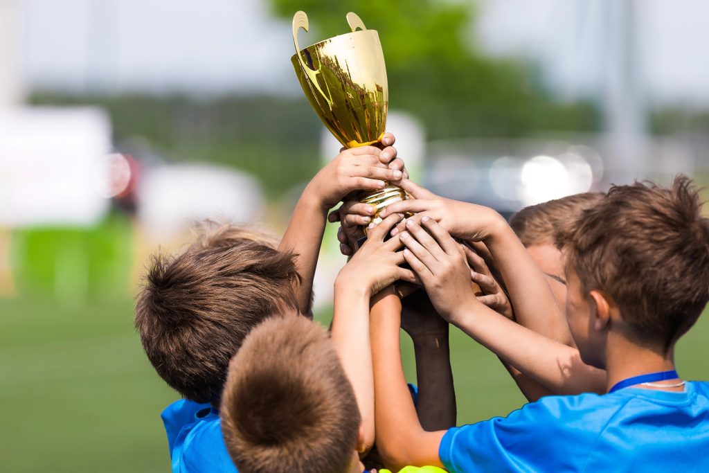 Soccer teammates holding up a trophy.